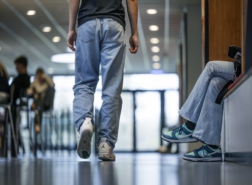 Billede der viser ben og fødder af en der går på en gang